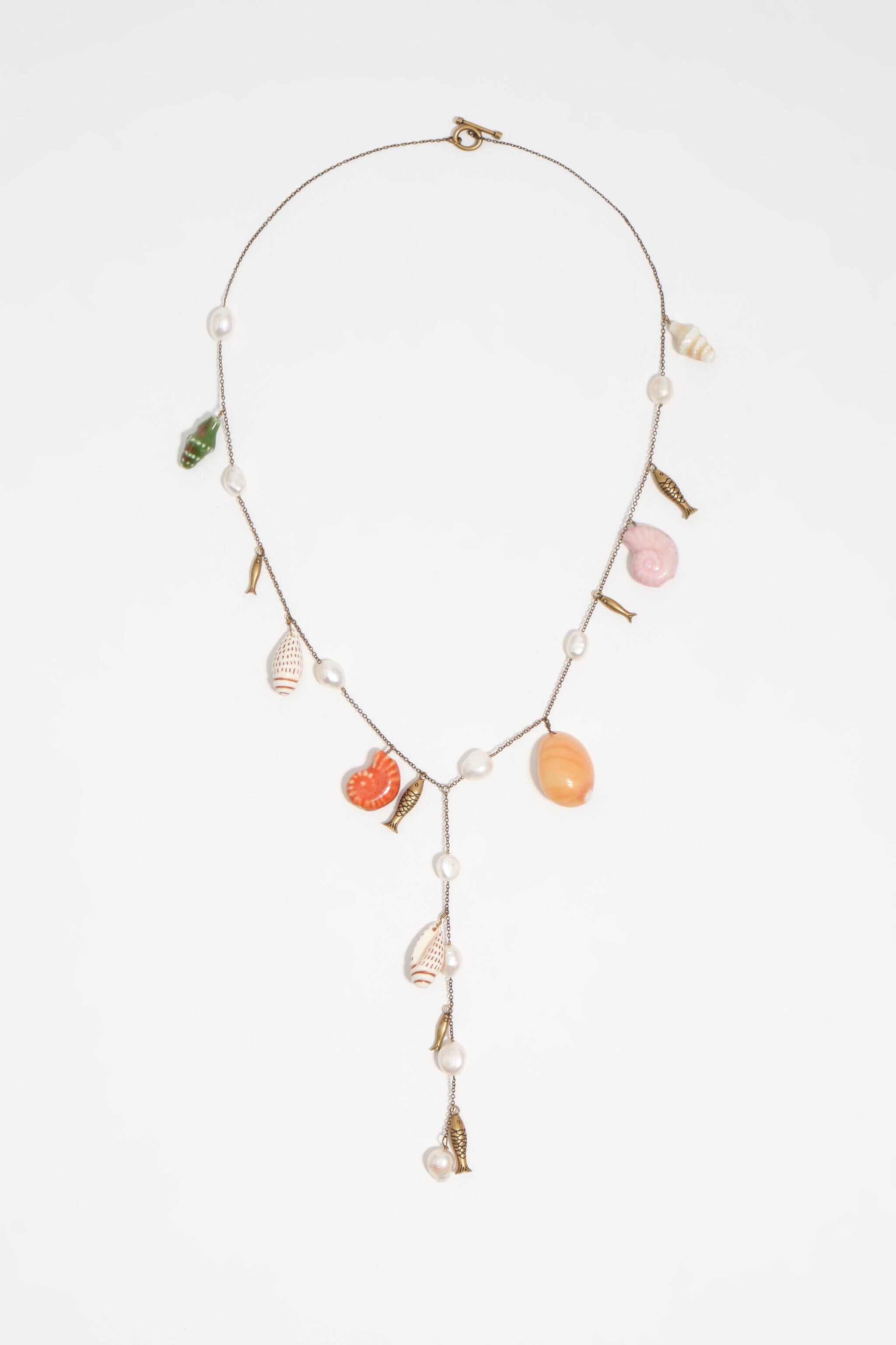 Gammal gul halsband med keramisk fisk och skal