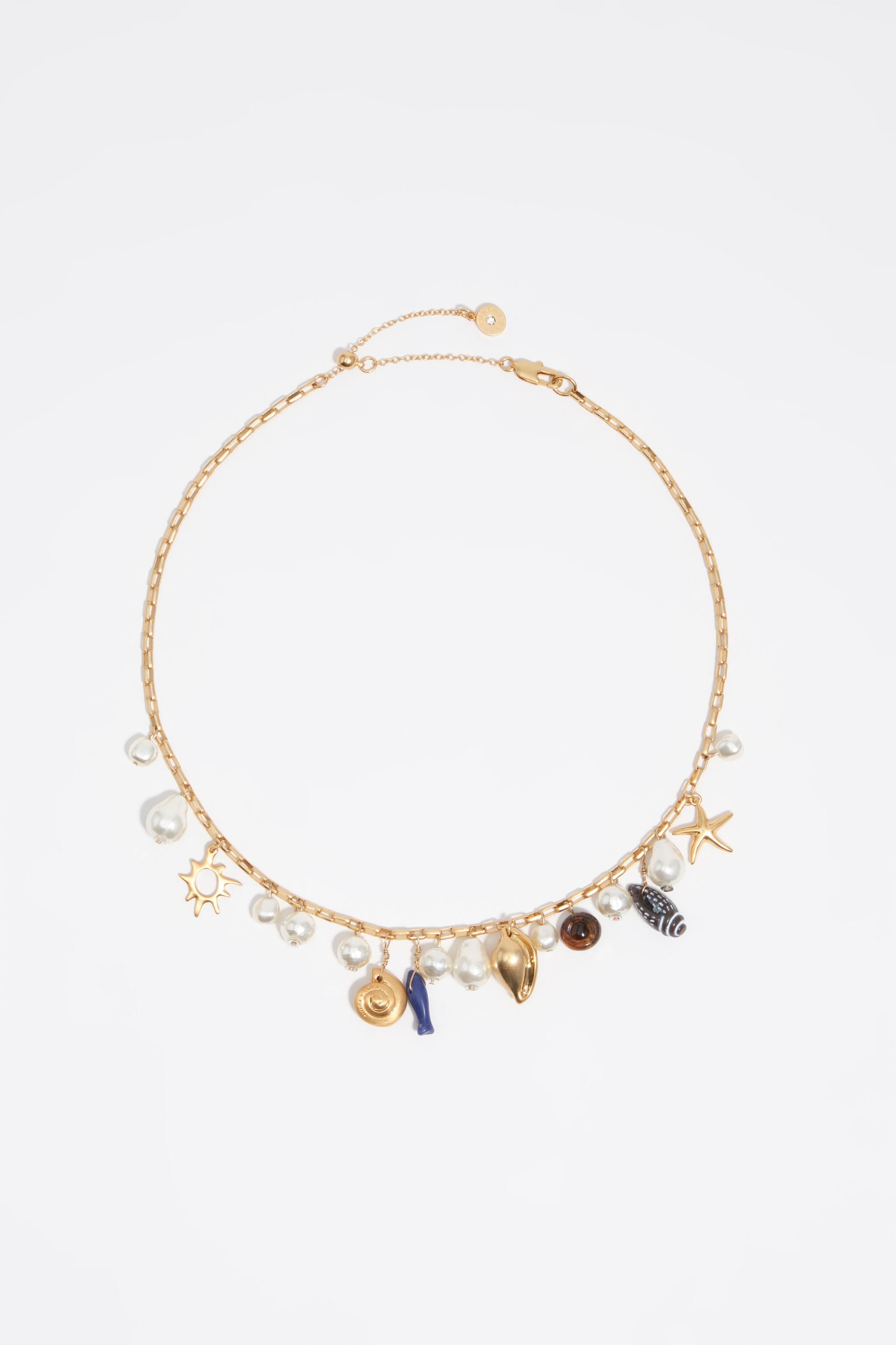 Gammal gul halsband med skal och fisk
